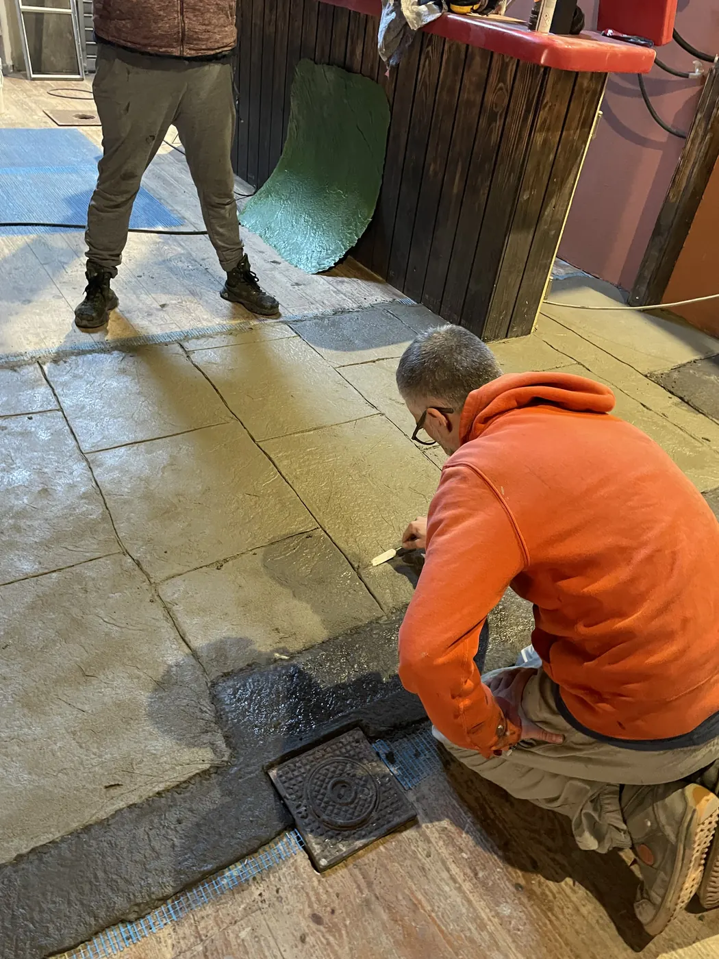 Peintre décorateur au travail sur un sol pavé