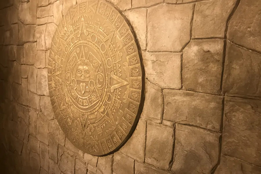 Disque aztèque en bas-relief sur un mur de pierre sculptée